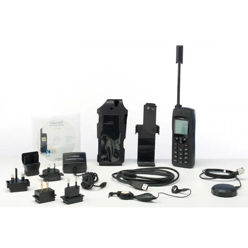 Everything in an Iridium 9555 rental kit laid out: handset, holster, chargers, adapters and cables